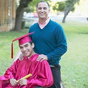 Portrait of a male graduate sitting in a wheel chair with a male lecturer standing behind him