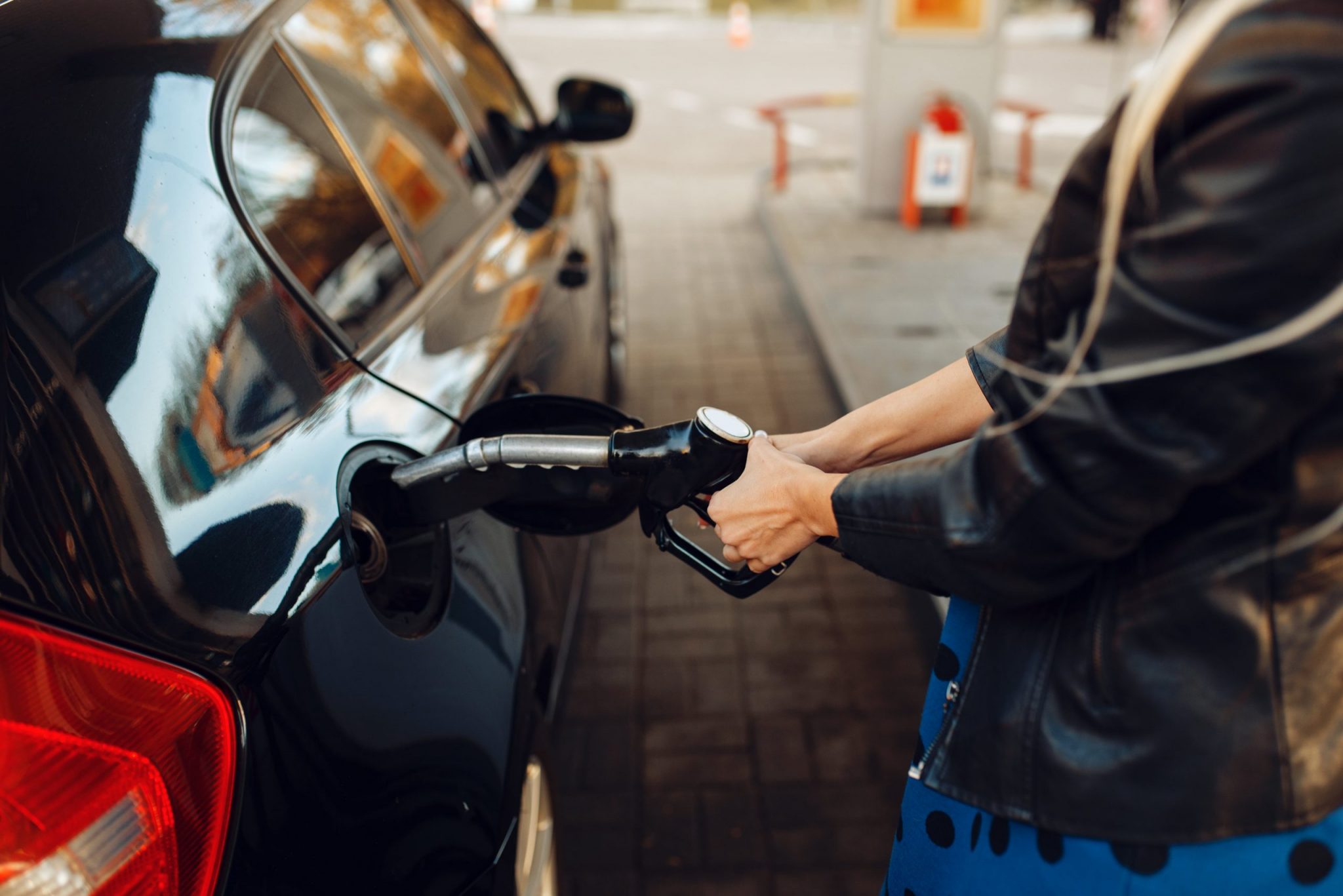 Petrol driven car. Заправляет машину. Женский автомобиль заправляется вином. Женщина с бензином пистолетом.